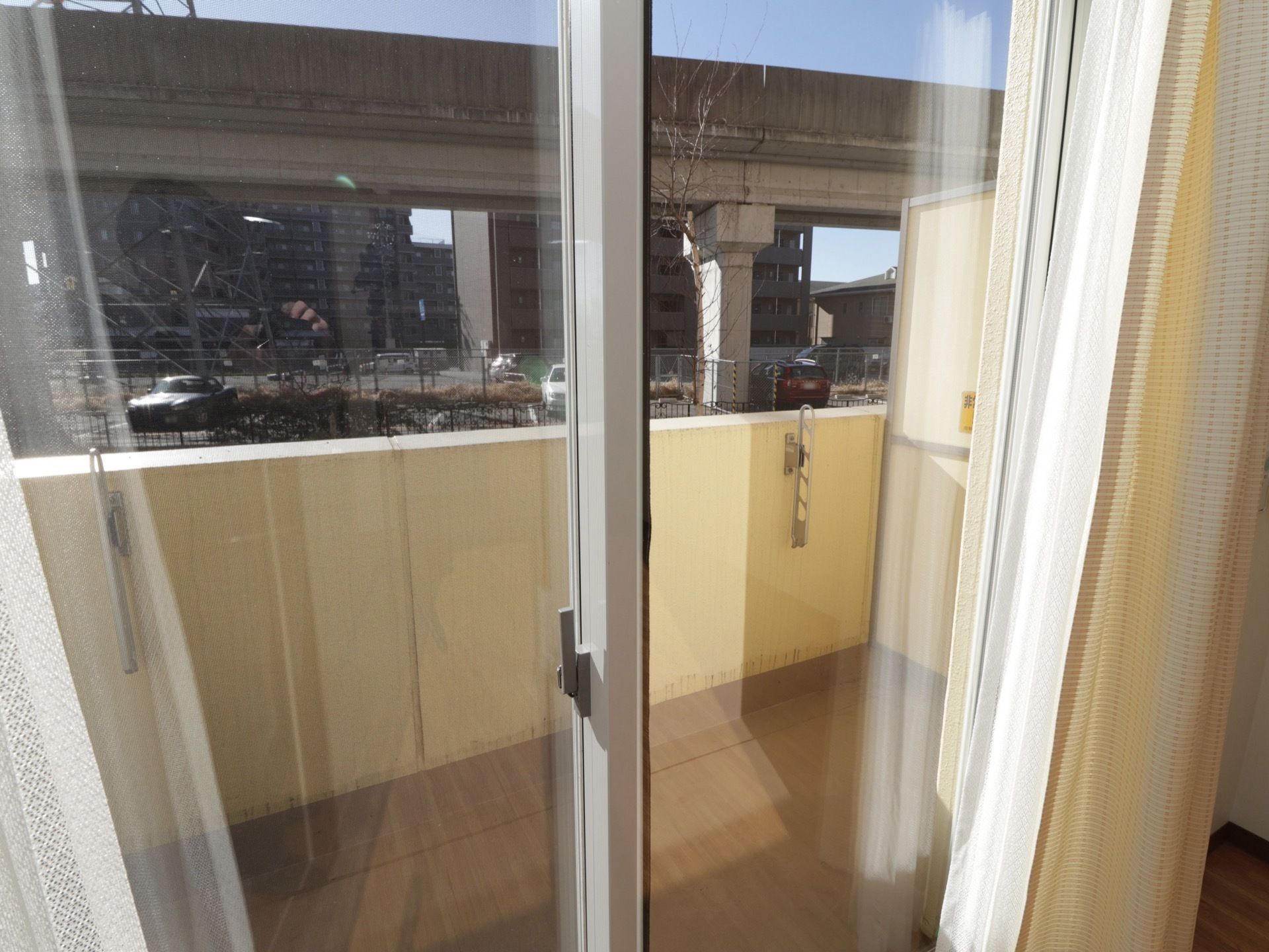 各居室にベランダを設けている。洗濯物竿を掛けられる設備がベランダの壁に取りつけられている。施設の前に電車が通っている。