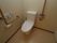 清潔感のある広々としたトイレである。温水洗浄便座やナースコール、手すり、折りたたみ式のバーが完備されている。