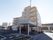 高級マンションを思わせるような５階建てのブラウン系の建物である。建物の周りには駐車スペースがたくさん用意されている。