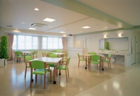 4脚のライトグリーンの椅子がセットされたテーブルが5つほど配置された食堂
