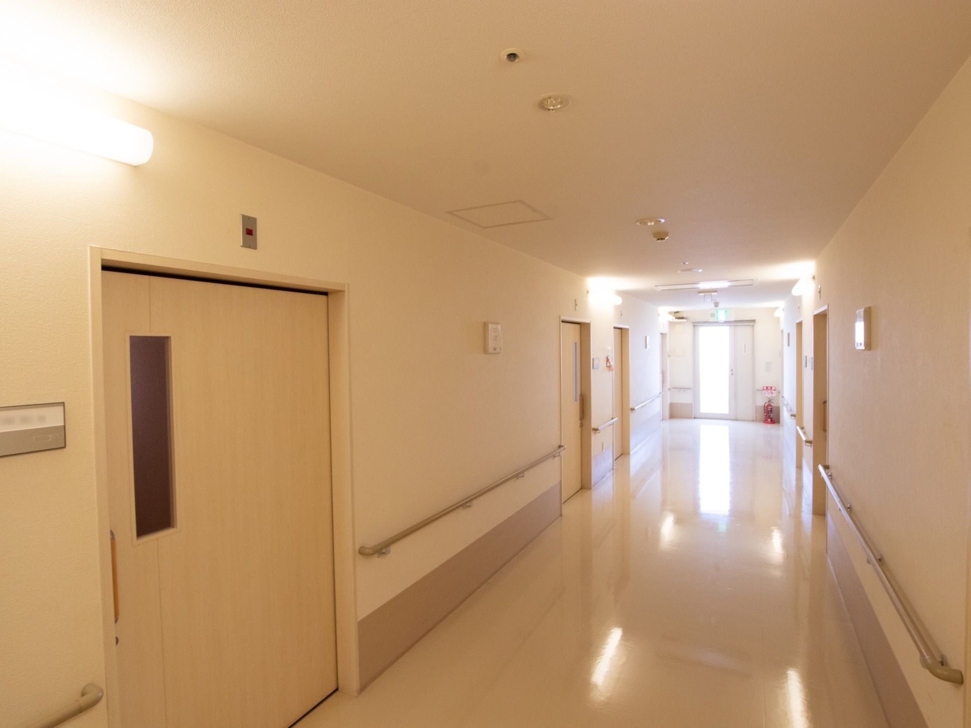 廊下は幅を広く確保している。突き当りは非常口になっている。居室への扉が並び、壁に手すりが設置されている。