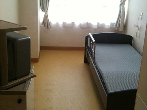 マットレスを敷いたベッドとテレビが置かれた一人暮らし向きの部屋