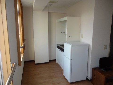 キッチンと冷蔵庫を備えた、一人暮らしに適した二畳ほどの部屋