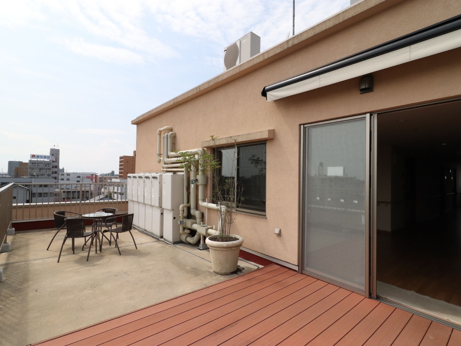 4人掛けのテーブルを配置した、街並みを見下ろせる屋上テラス