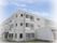 白い建物の３階建てで、一般のマンションと変わらない外観。入口には段差がなく出入りがしやすい。各部屋の窓が大きく明るい印象である。