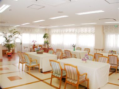 色とりどりの模様の椅子や花、レースのカーテンで可愛らしく設えられた食堂