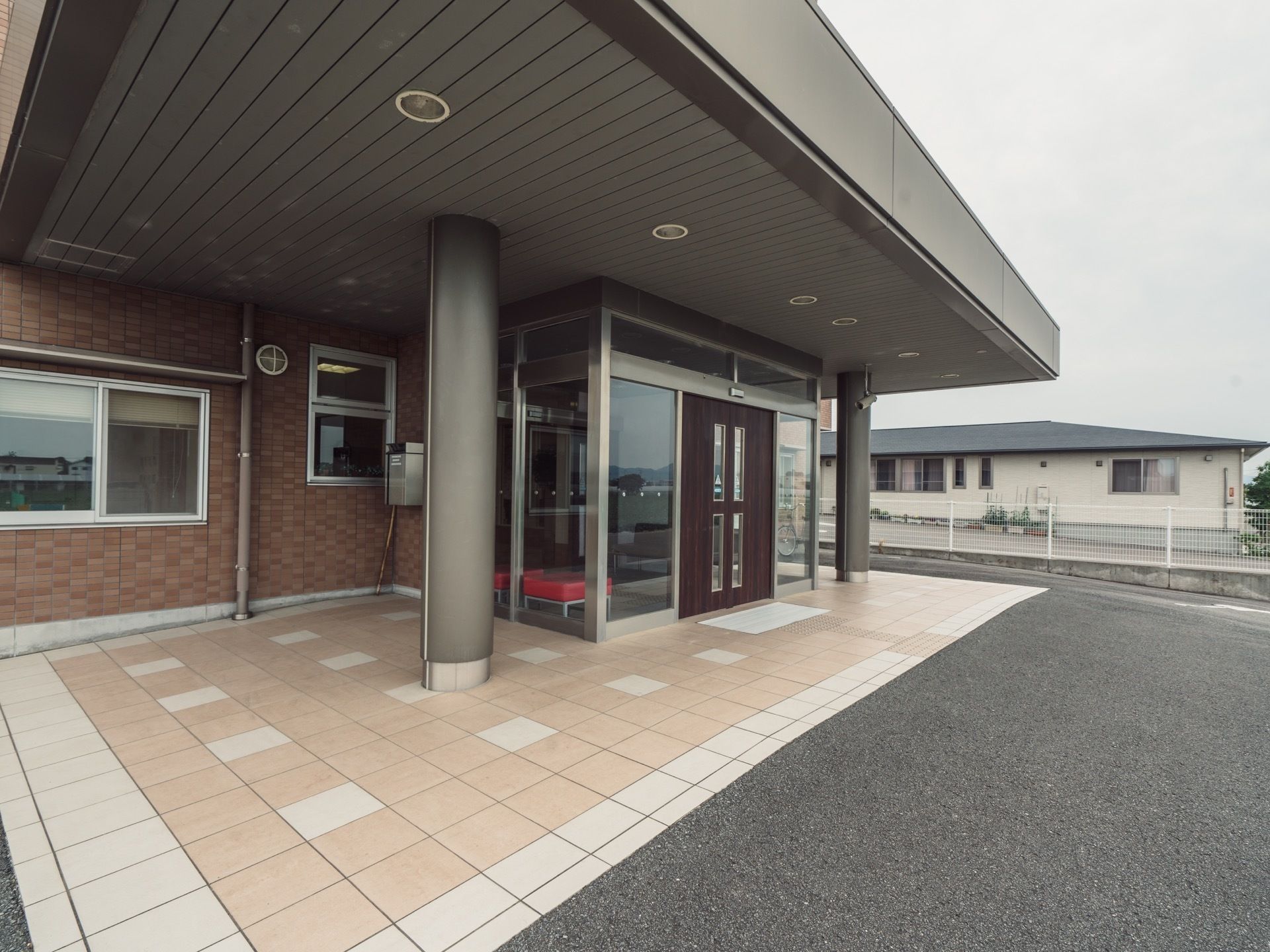 外から見た正面玄関口。自動ドアのスライドする部分は総ガラス張りではなく、塗装された木材のようなデザインとなっている。