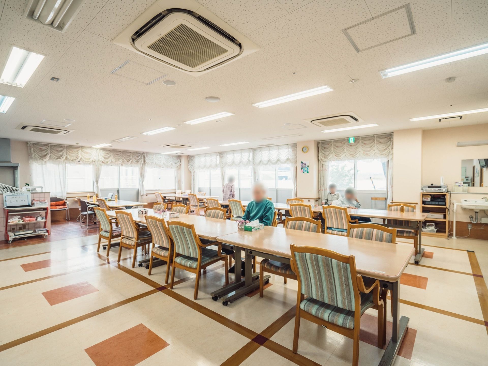 建物の一回に設けられている大きな食堂。床の材質は、白地に茶色い格子状の模様が入ったデザインタイルとなっている。