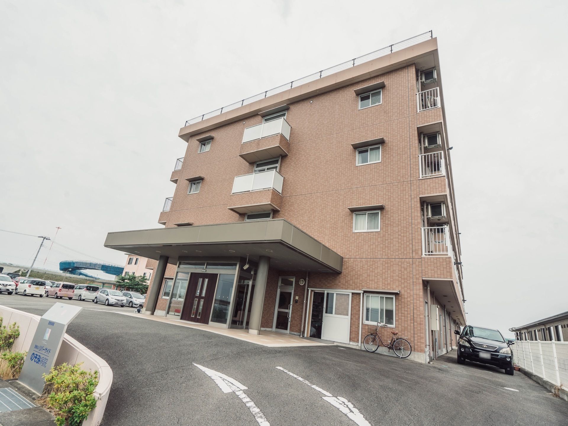 ４階建て構造となっている施設建物。２階から上は居室の設けられた居住フロアになっており、バルコニーが作られている。
