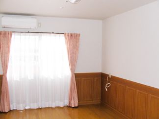 ピンク色のカーテンが可愛らしい大きな窓のあるワンルーム