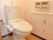 消毒済みのウオッシュレットトイレが設置されている。右手の壁には手すりがあり下にはナースコールも取り付けられています。