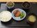 揚げ物にソースがかかり野菜とともに皿に乗っている、他にも2品の小鉢にごはんに味噌汁と純和風な食事が提供されている。
