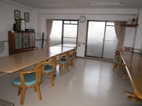 長テーブルと背もたれのある椅子が2列に設置された明るい食堂