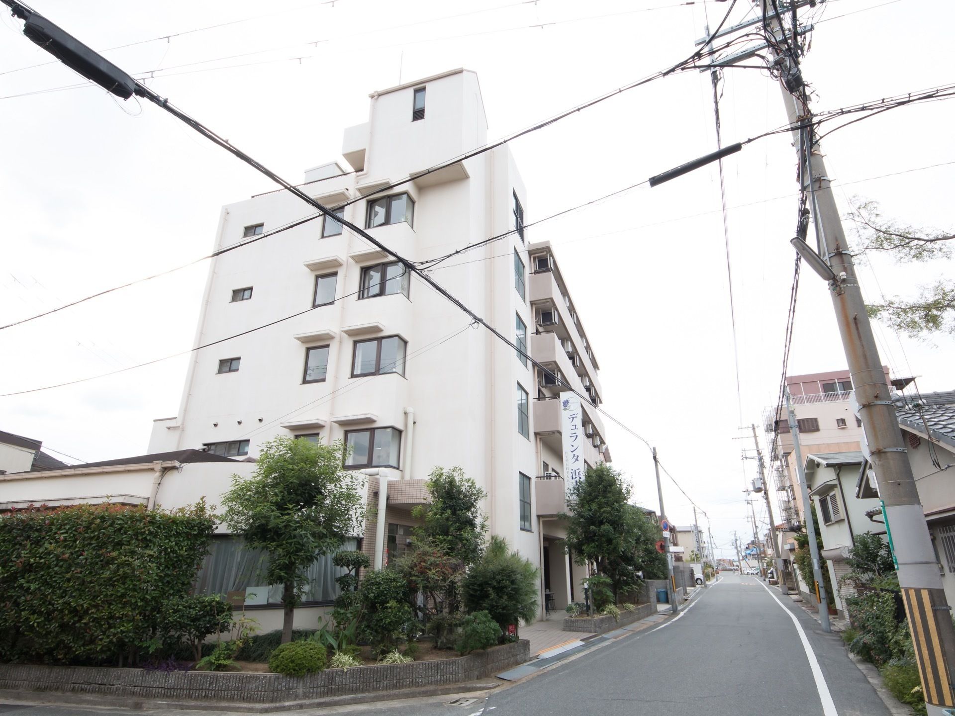 5階建てのマンションタイプの住宅型ホームである。壁は白く、玄関には看板がついている。窓やベランダが多く設置されている。