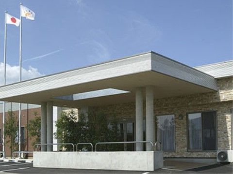 入口のドア付近には大きな屋根があり、目隠しになる木々が置いてある。２本の旗立てがあるのが目印である。