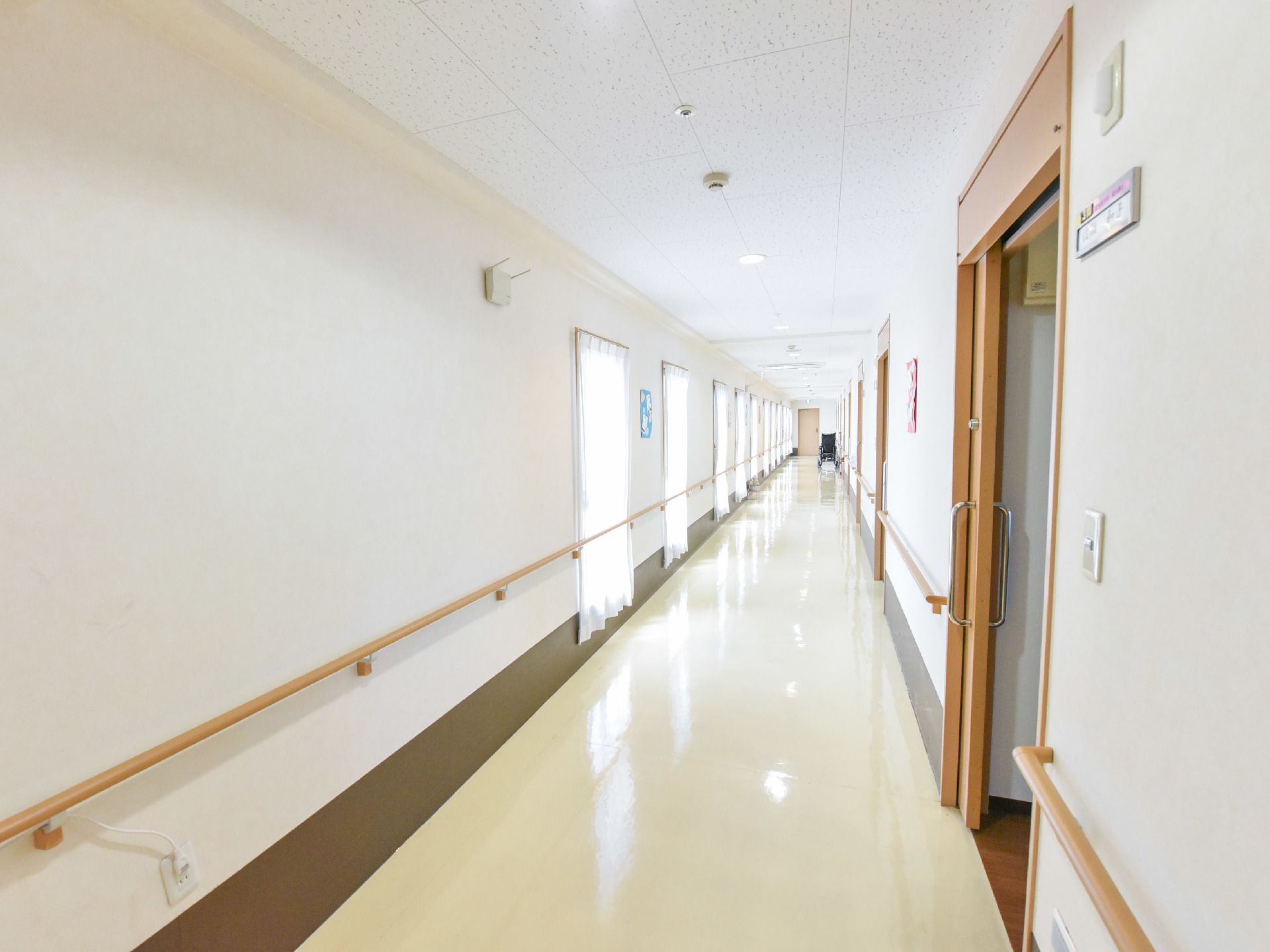 窓に面した個室の連なる廊下。廊下には利用者の転倒防止のため、両サイドに手すりが設けられているので安心。