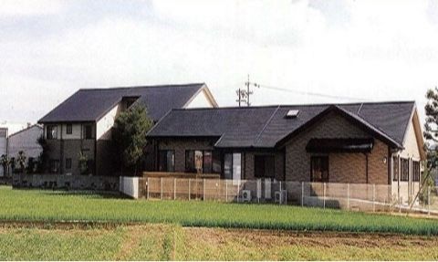 田んぼの中に建つ、切妻屋根の1階建てと2階建て建物