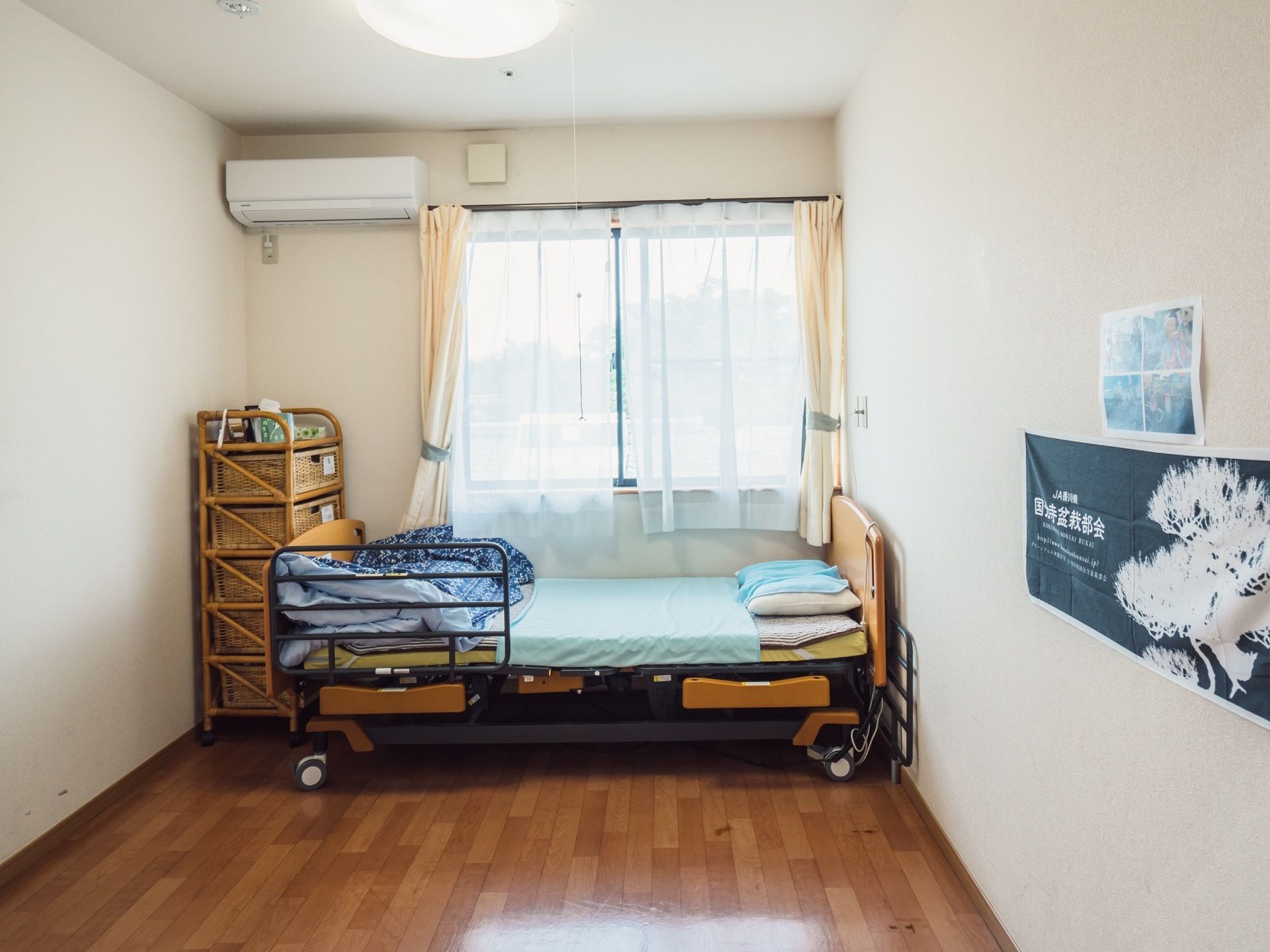 大きな窓がある居室は、日当たりが良い。壁には写真やポスターを飾ることができる。エアコンと介護用ベッドが備え付けられている。