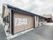 建物の壁に施設の看板がある。赤い帽子をかぶったキャラクターが描かれており、３つの施設の行く先を案内している。