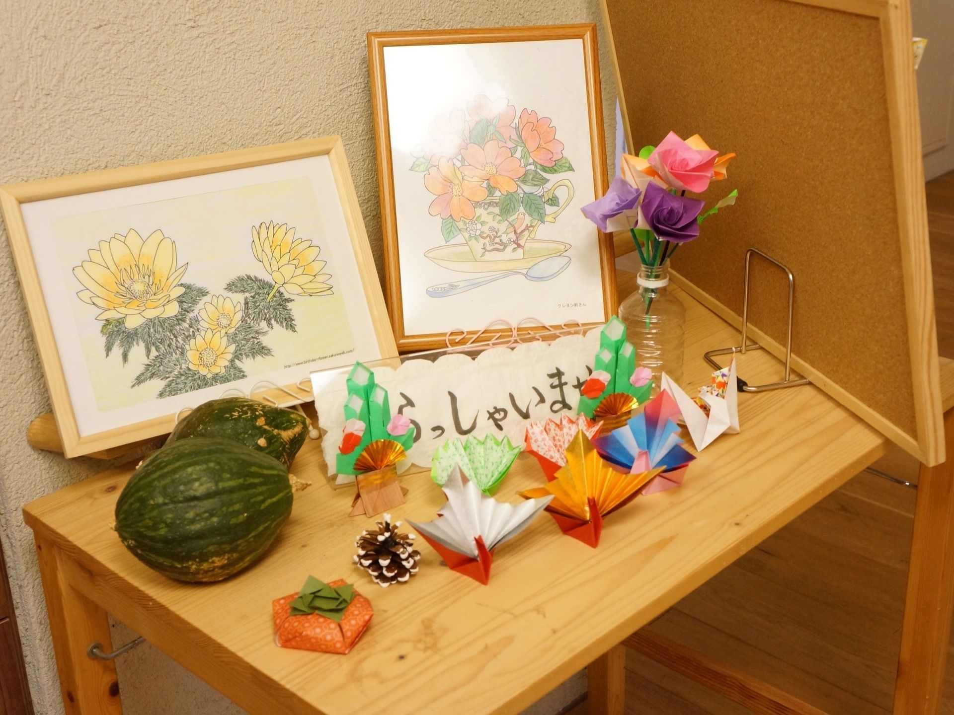 花の絵、折り紙の鶴や花の他、かぼちゃが置かれた受付テーブル