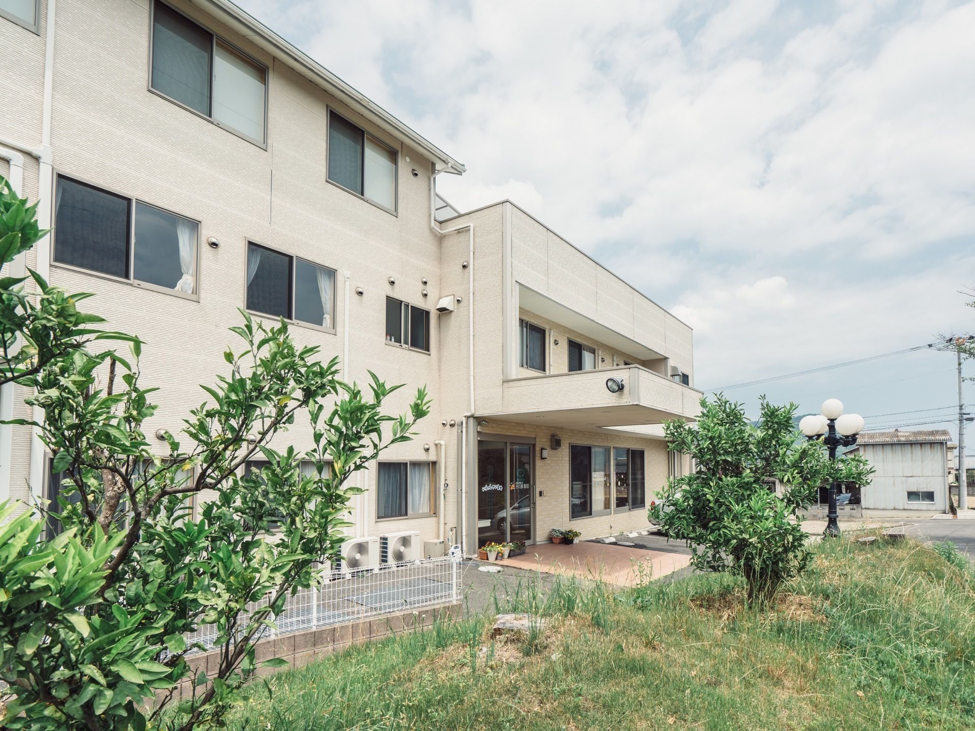 施設の目の前に木が２本植わっている。大きな建物が周辺にないので視界を遮るものがなく、日当たりがよい。