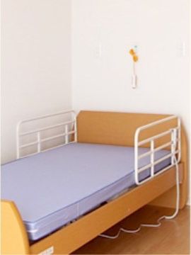 居室にはベッドを設置している。転落防止用の柵を取り付けており、夜も安心して眠ることができる。近くの壁には呼び出しボタンがある。