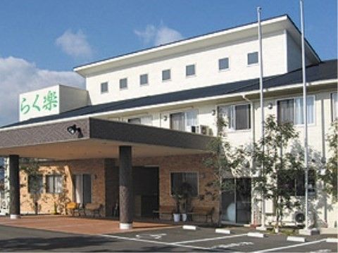 屋根の上に大きな施設名看板が設置され、エントランス部分が広々としたモダンな建物