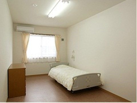 居室には介護用ベッドと小さなタンスを置いている。入居者様がお好きなインテリアにして、自宅のようにくつろぐことができる。