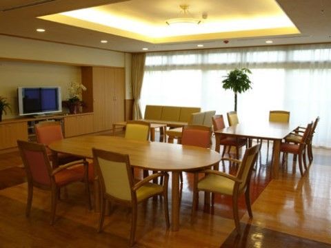 6人掛けのダイニングセット2組と、テレビやソファが設置された広間