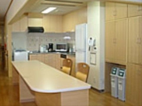 L字型のキッチンスペースの手前に設置されている細長いテーブルと2脚の椅子