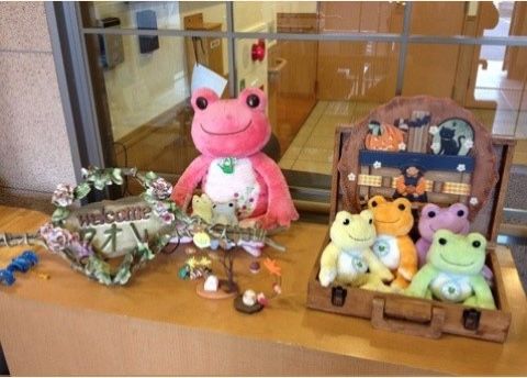 窓口のカウンターに飾られたカエルの置物と施設名プレート