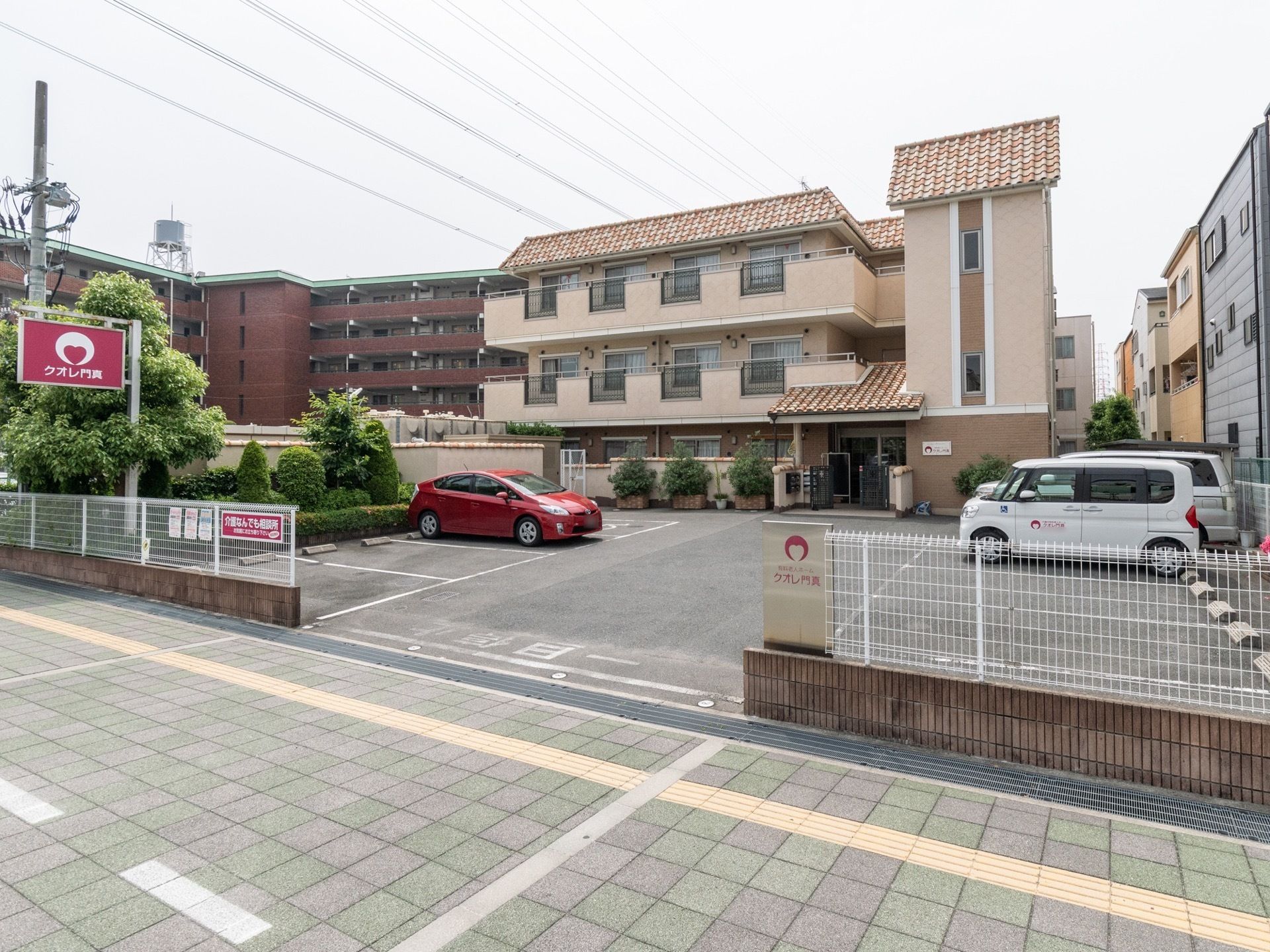 閑静な住宅地に洋館風の3階建物。その前には、専用の駐車スペースが完備されていて来訪しやすい作りとなっている。