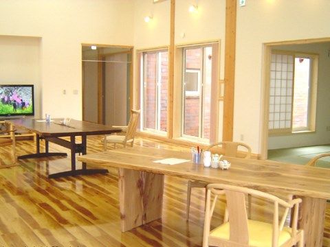 暖かみのある木目の床やテーブルが並んだ共有スペース