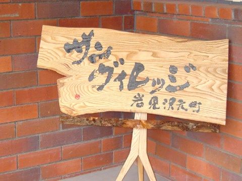 施設名が手書き風に記載しており、壁に立てかけられているお手製の看板