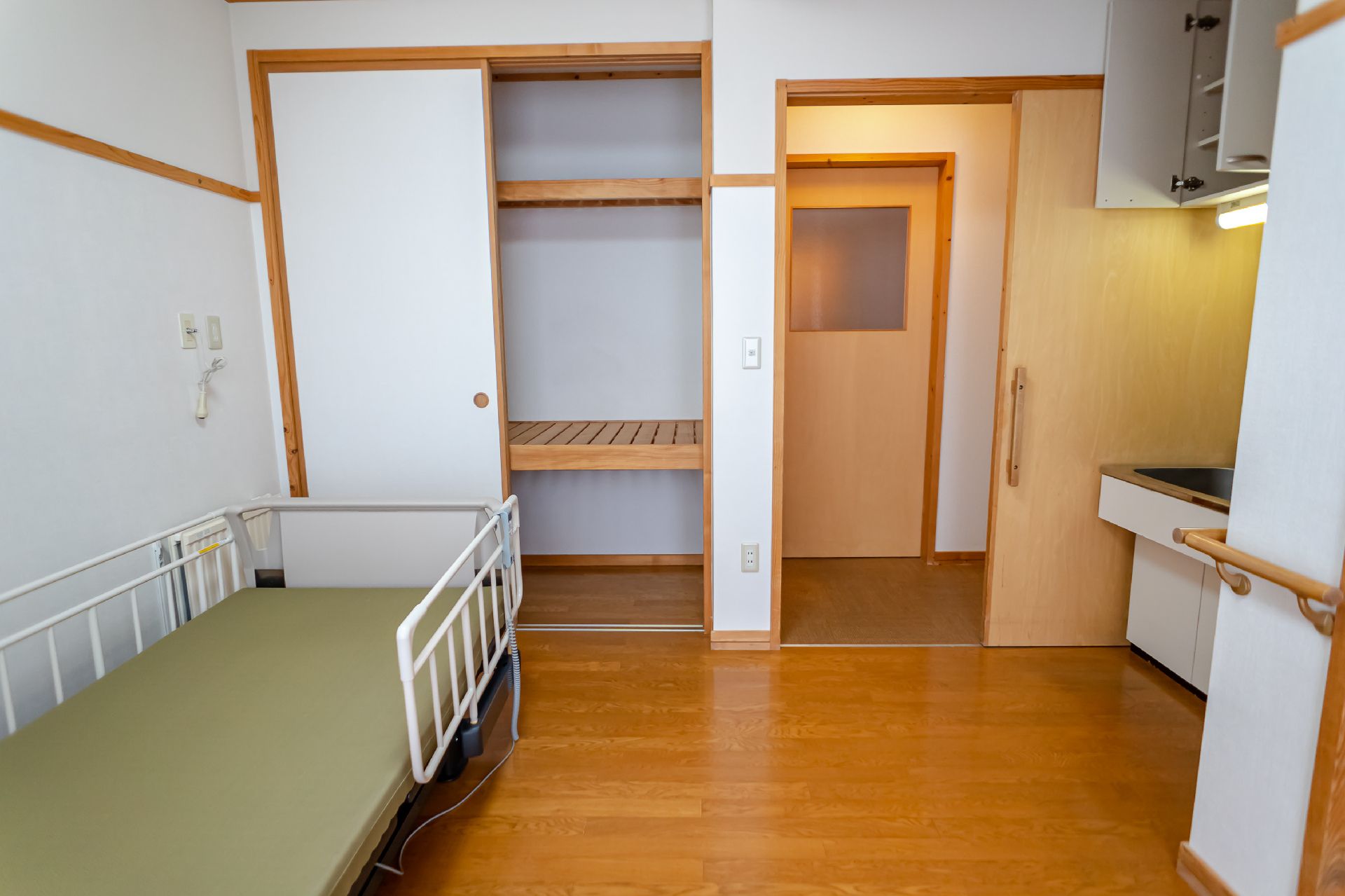 ベッドとクローゼットがある白い壁の部屋
