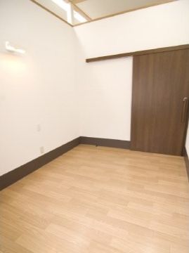 程よい広さの居室は、スライドドアの出入り口が付いている。壁の上部が横に長い窓になっており、明るい室内である。