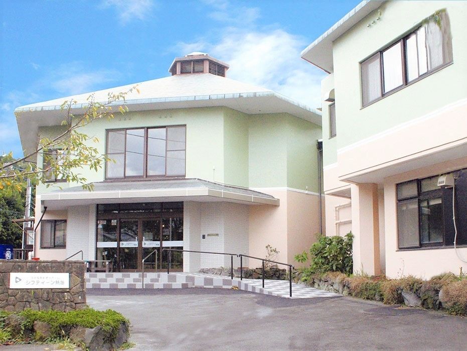 外壁にパステルカラーの塗装が施された２階建ての建物２棟