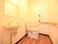 奥行きのあるトイレに、便座が横向きに取りつけてある。壁にガッチリと固定する形で手すりが設置されている。