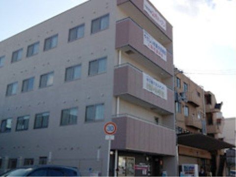 ベランダに横断幕が取り付けられている鉄筋コンクリート造りの４階建ての建物