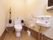 使いやすい広さのあるトイレには、温水洗浄便座と洗面台が設置されている。便座の周囲には手すりなどが設置されている。