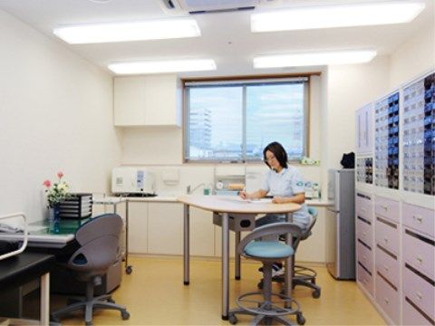 引き出し式収納棚が設置されている室内で書類に目を通しているスタッフ