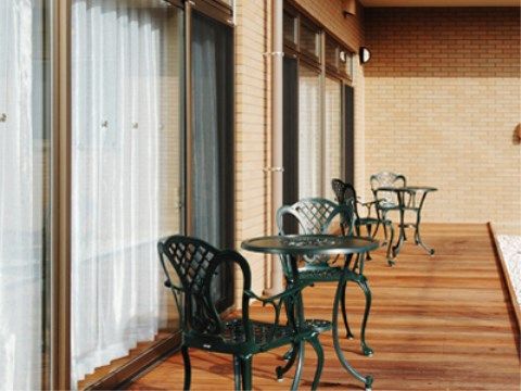 屋外用のテーブルと椅子が置かれた窓の外のデッキスペース