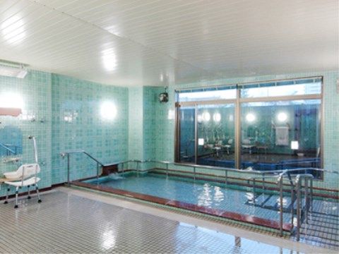 広い洗い場が設けられた大浴場である。浴室の壁は涼しげな水色を基調としており、浴槽周りには手すりが設置されている。