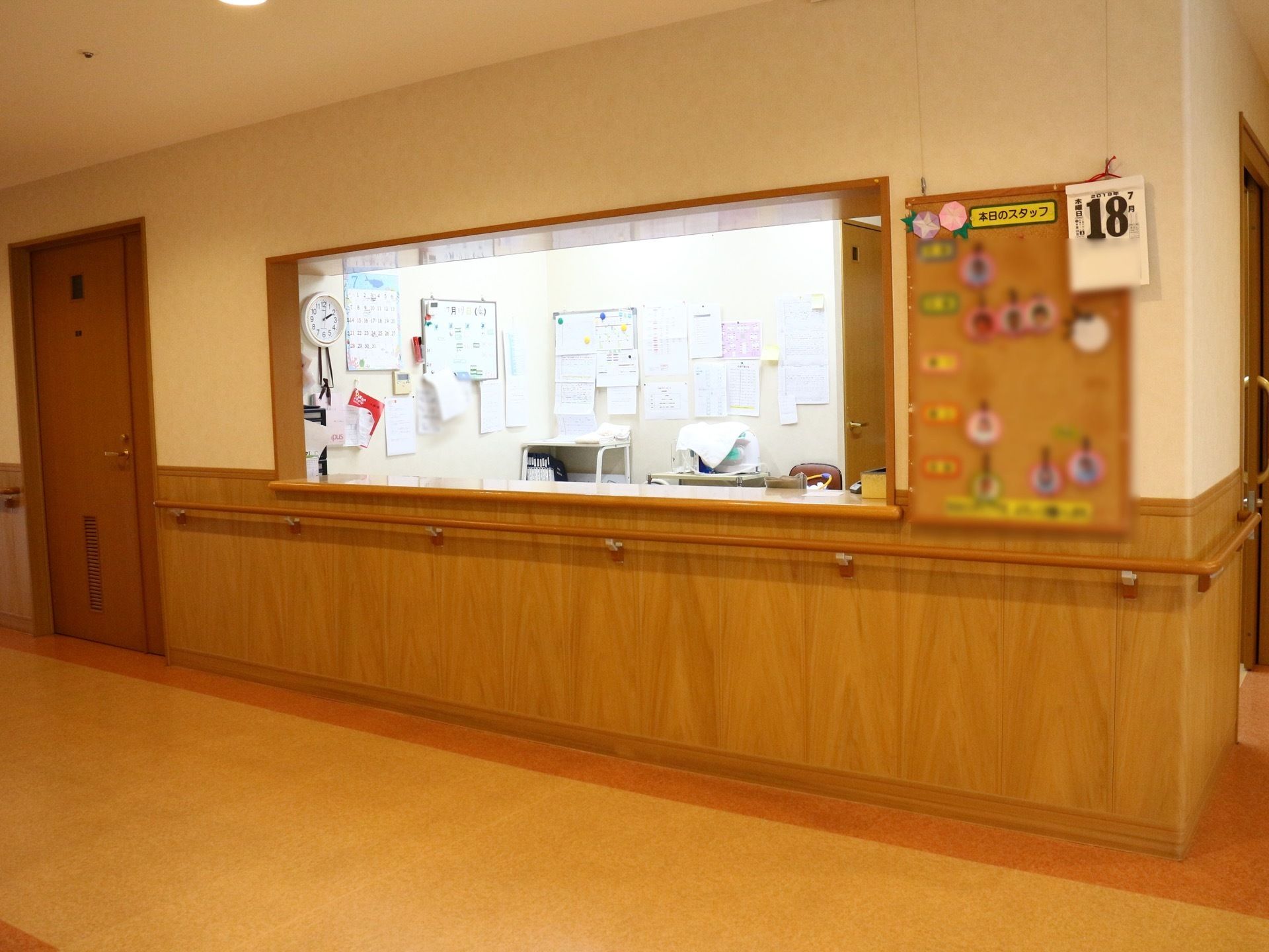 オープンカウンターの受付がある。横の壁には、その日勤務しているスタッフの名前と顔写真が掲示されている。