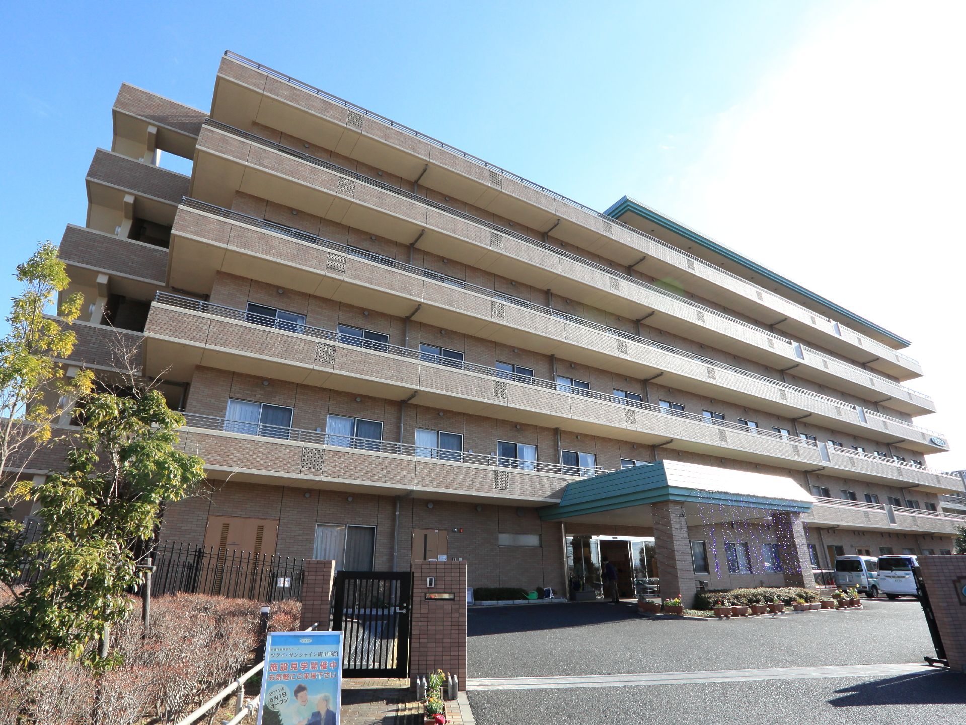 「ツクイ・サンシャイン町田西館」の外観。淡いベージュの親しみやすいデザイン。