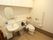 白を基調とし清潔感があるトイレには、しびんやバケツを洗うためのシャワーが付いている。手すり、ナースコール、自動給水の鏡付手洗い場もある。