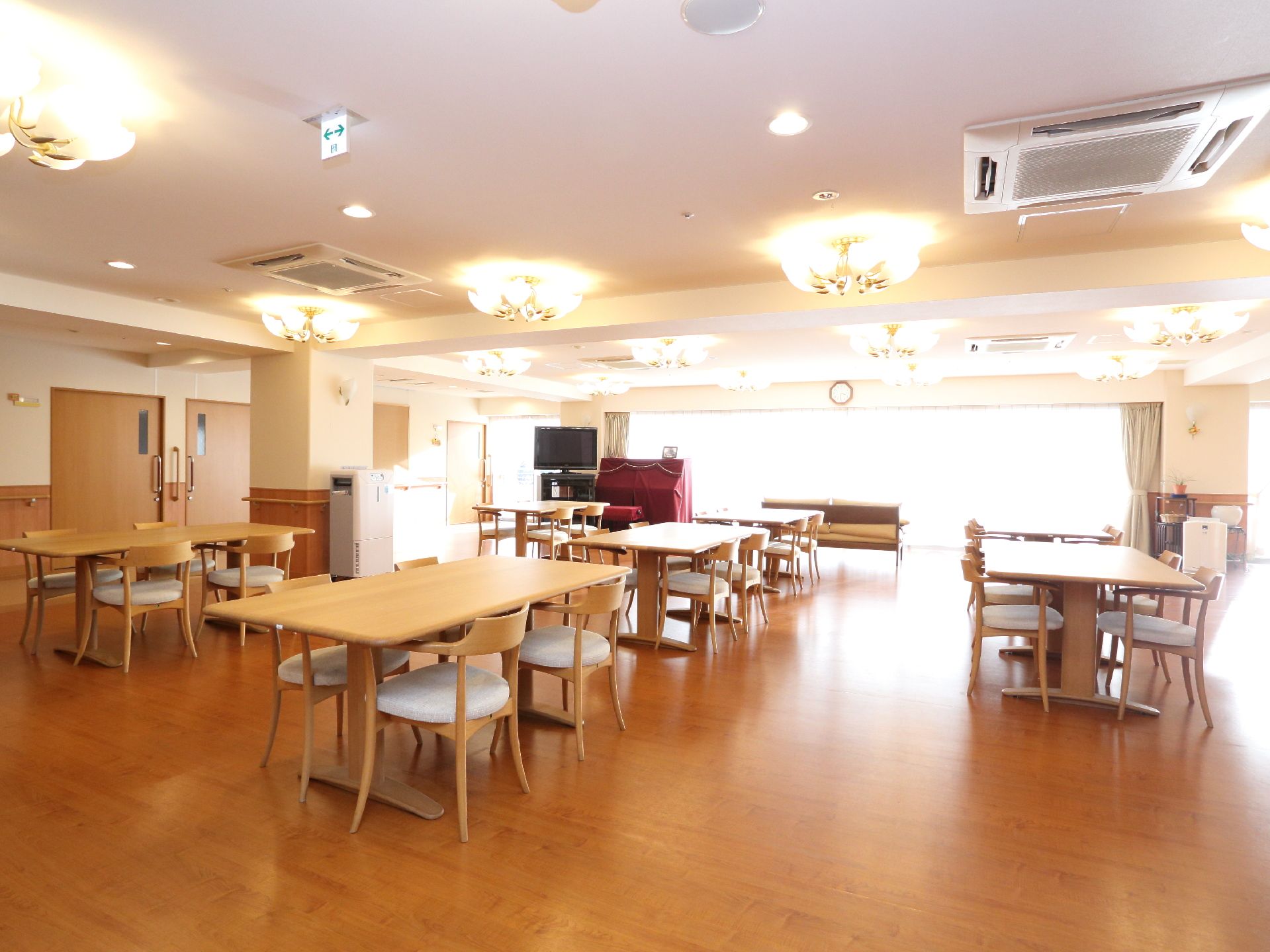 窓のそばにテレビとアップライトピアノが置いてある食堂で、食事以外にも娯楽の場として入居者が利用できる。