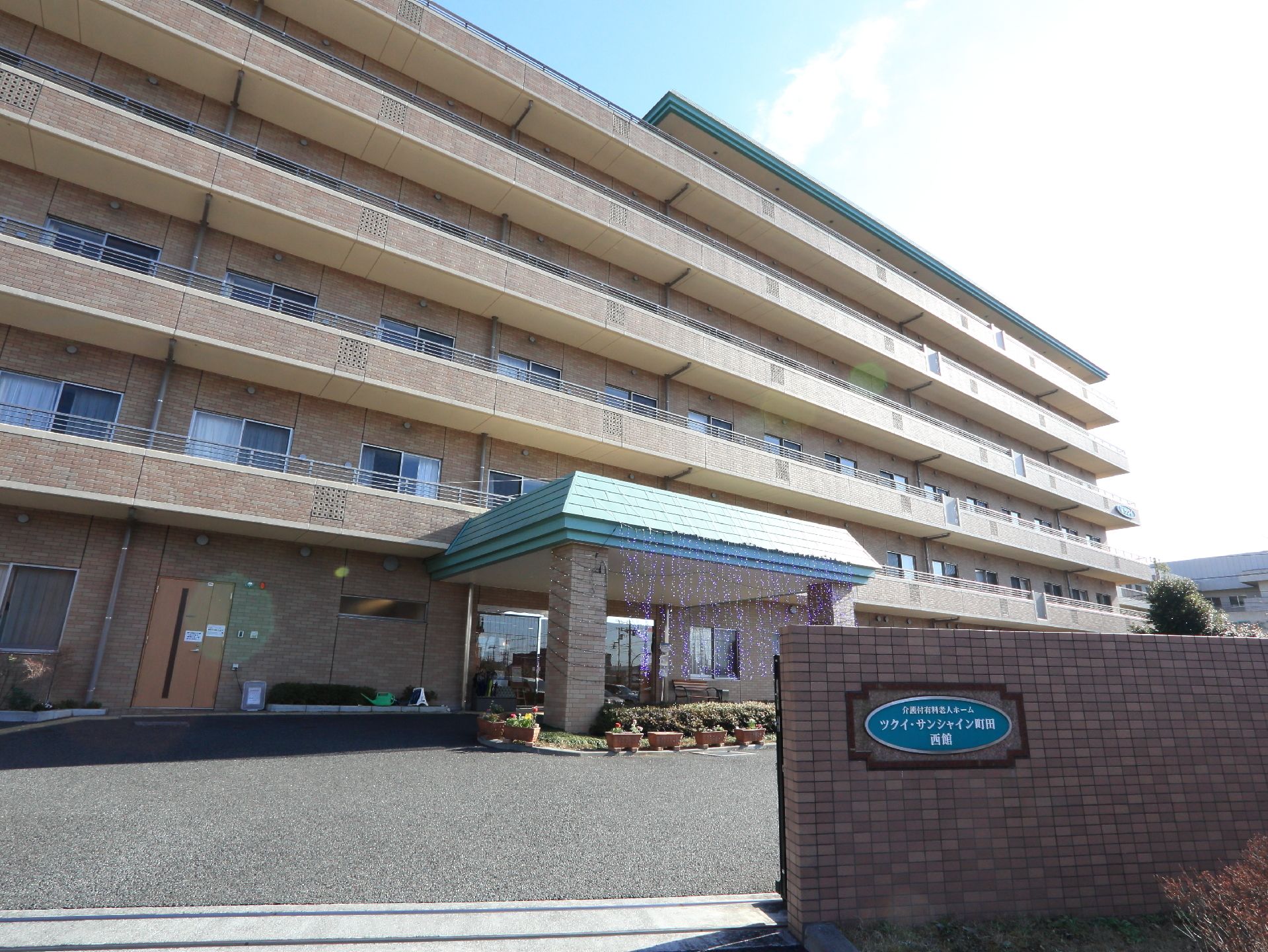 大きなマンション風の立派な外観で、建物も門もレンガ調で統一されている。門にはミントグリーンの表札がかかっている。