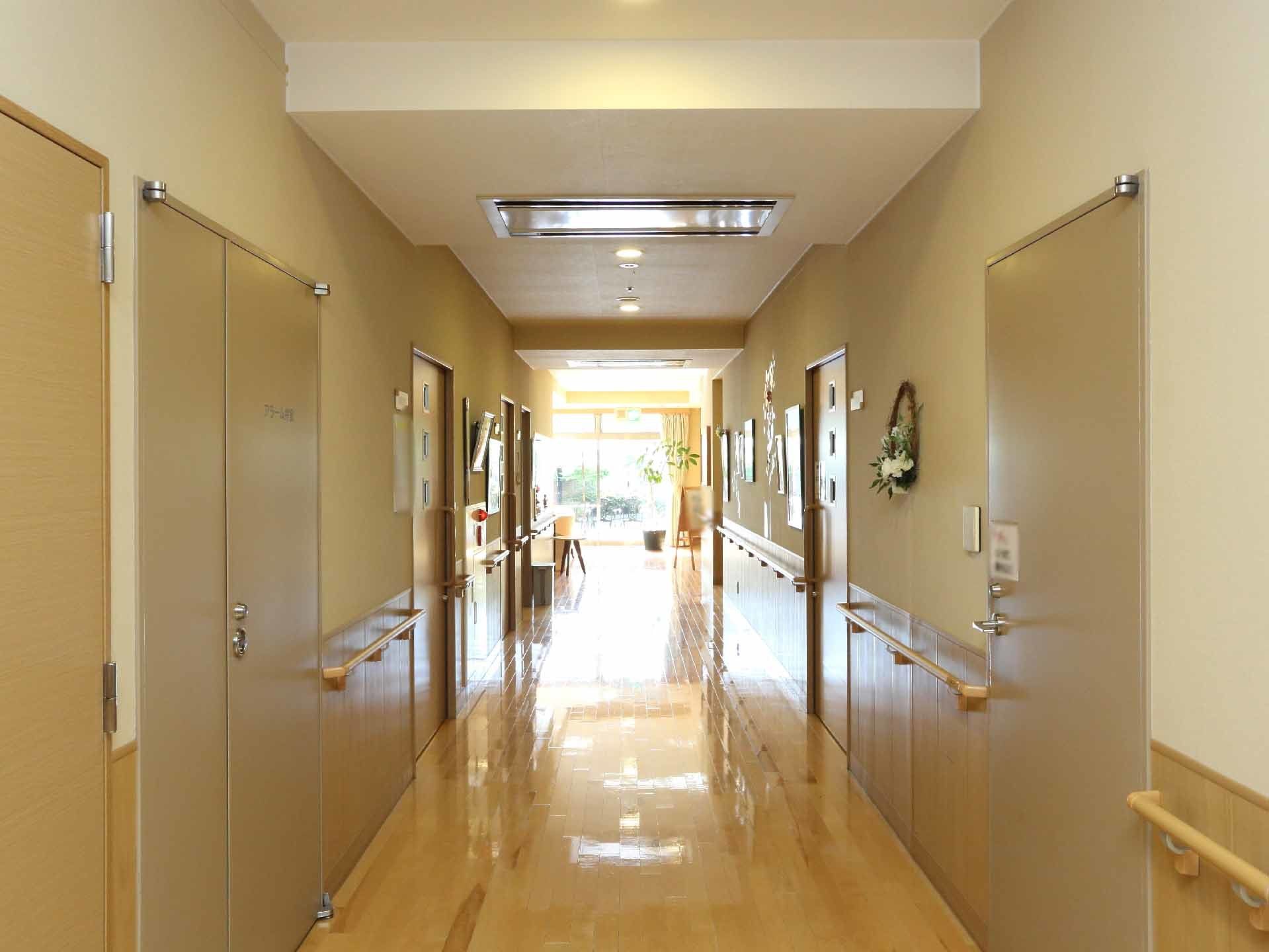 廊下には、両端に手すりがついているほか、ドアが見えるので部屋が設けてある。床はバリアフリーとなっている。
