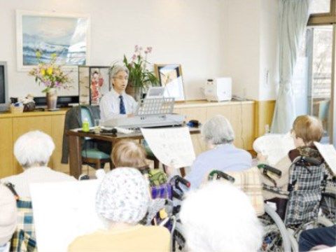 歌の会のレクリエーションで講師から指導を受ける入居者たち